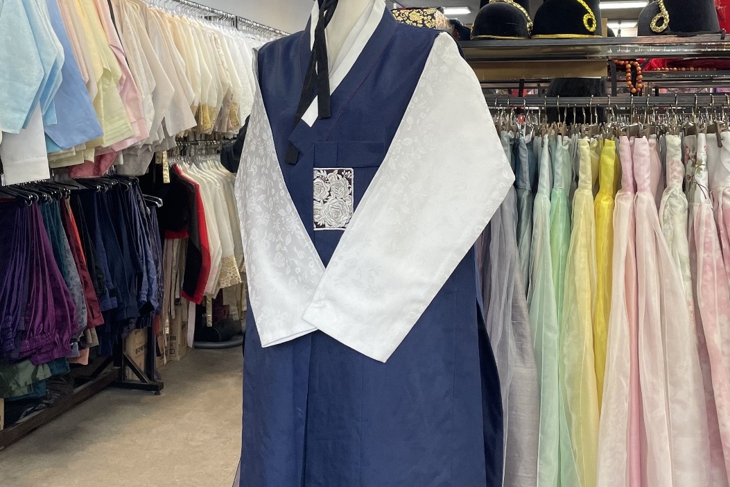 Special Men's Hanbok with ivory top and deep blue bottoms on a mannequin at InKorea Hanbok rental.